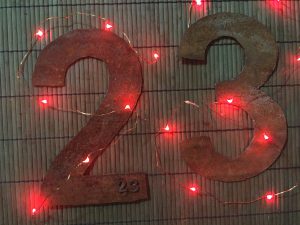 the number 23 cut out of wrought iron surrounded by red lights